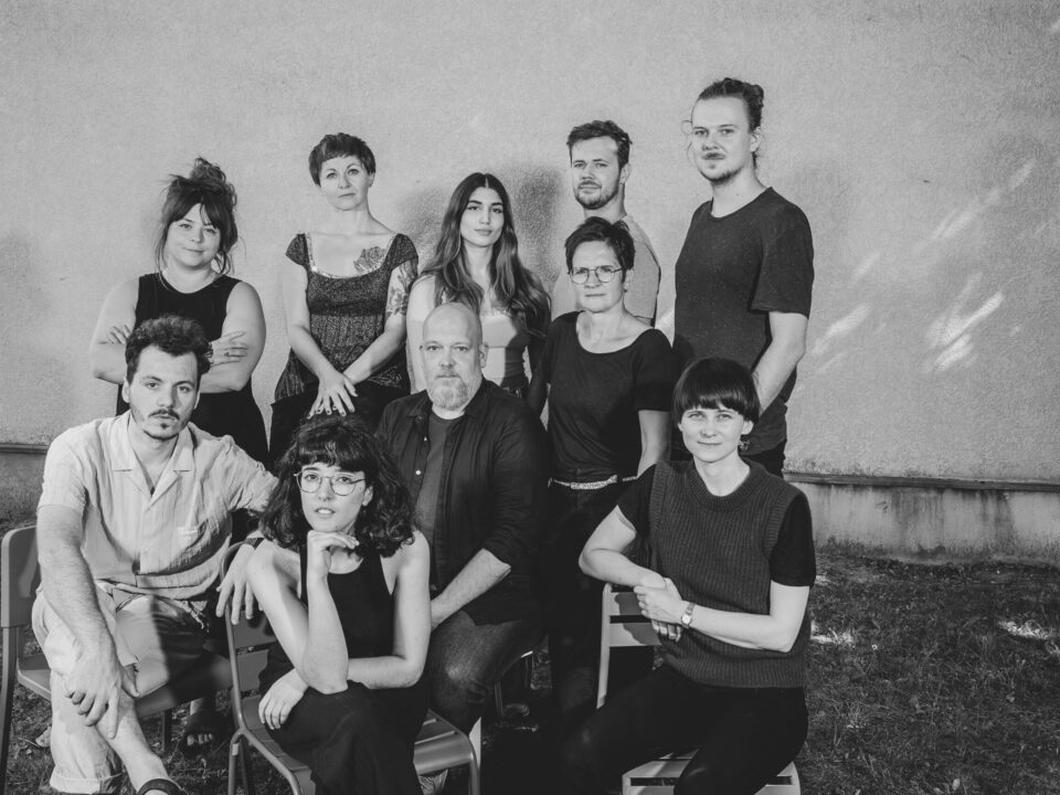 Schwarz-weiß-Foto: Eine Gruppe von zehn Menschen, vier Männer und sechs Frauen. Gruppenfoto, alle schauen in die Kamera.