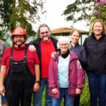 Eine Gruppe von sieben lächelnder weißer Menschen im Wald